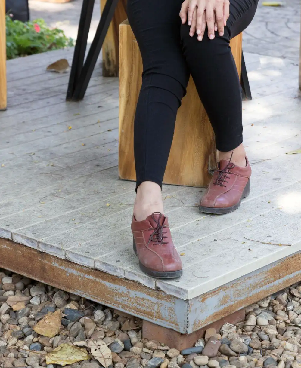 Girl wearing black pants and brown leather shoes