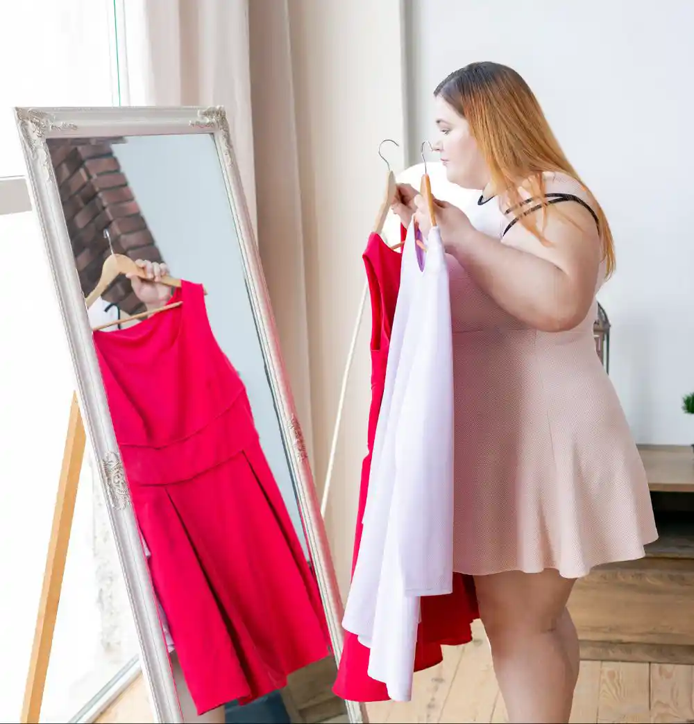 Pleasant chubby woman choosing what to wear