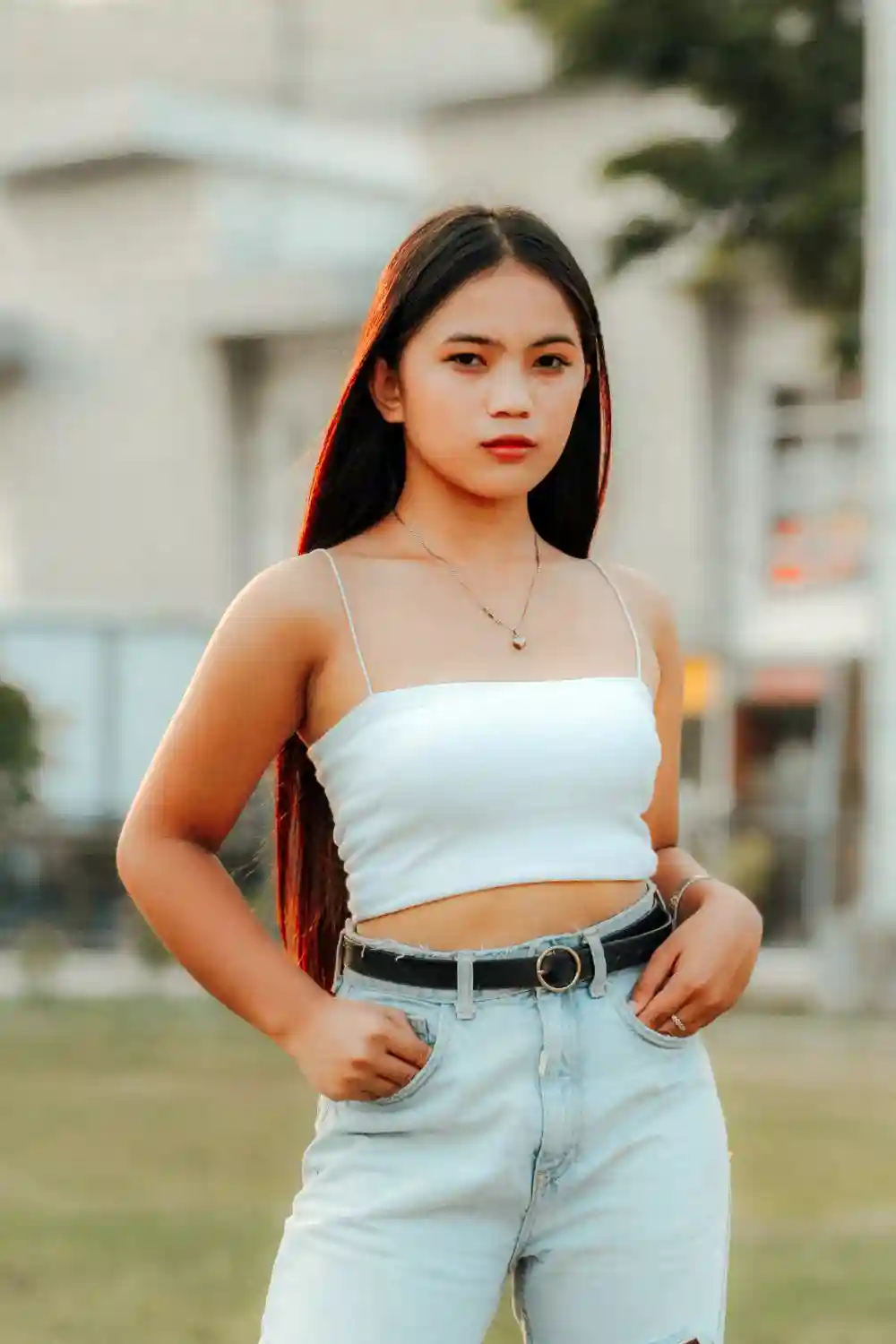 A Woman Wearing a White Tank Top and Denim Jeans