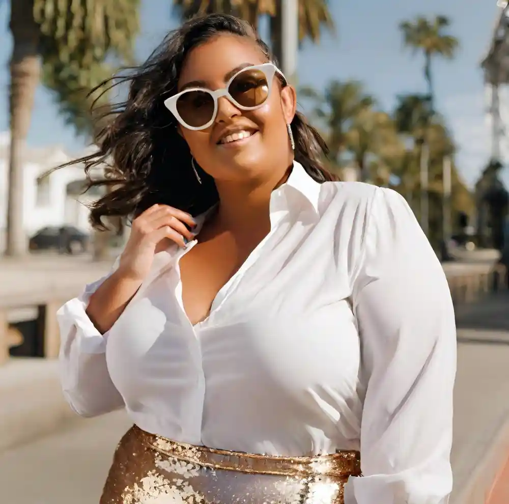 Model wearing crisp white blouse with sequin skirt