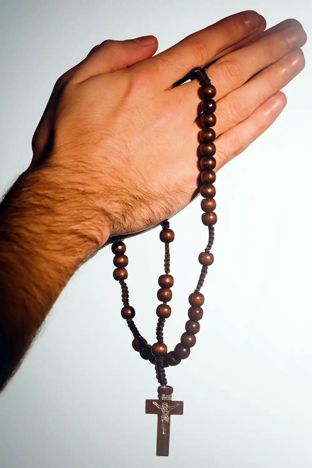 Hand holding rosary beads